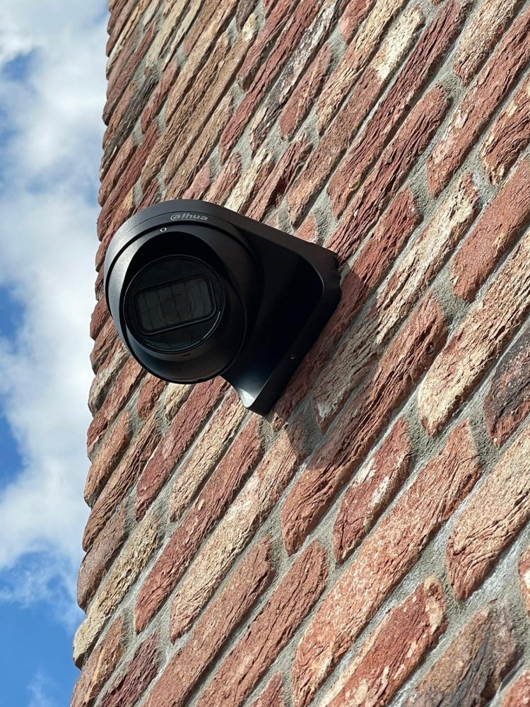 Beveiligingscamera gemonteerd aan een bakstenen gevel