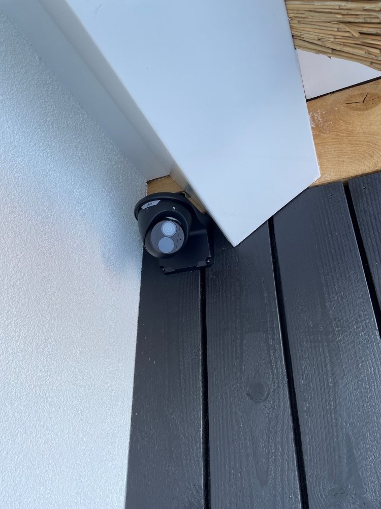 Buitencamera gemonteerd op een zwarte houten gevel