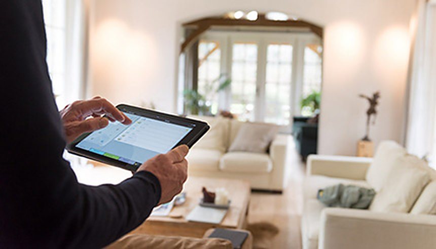 Bewoner bedient de installatie met een tablet vanuit de woonkamer