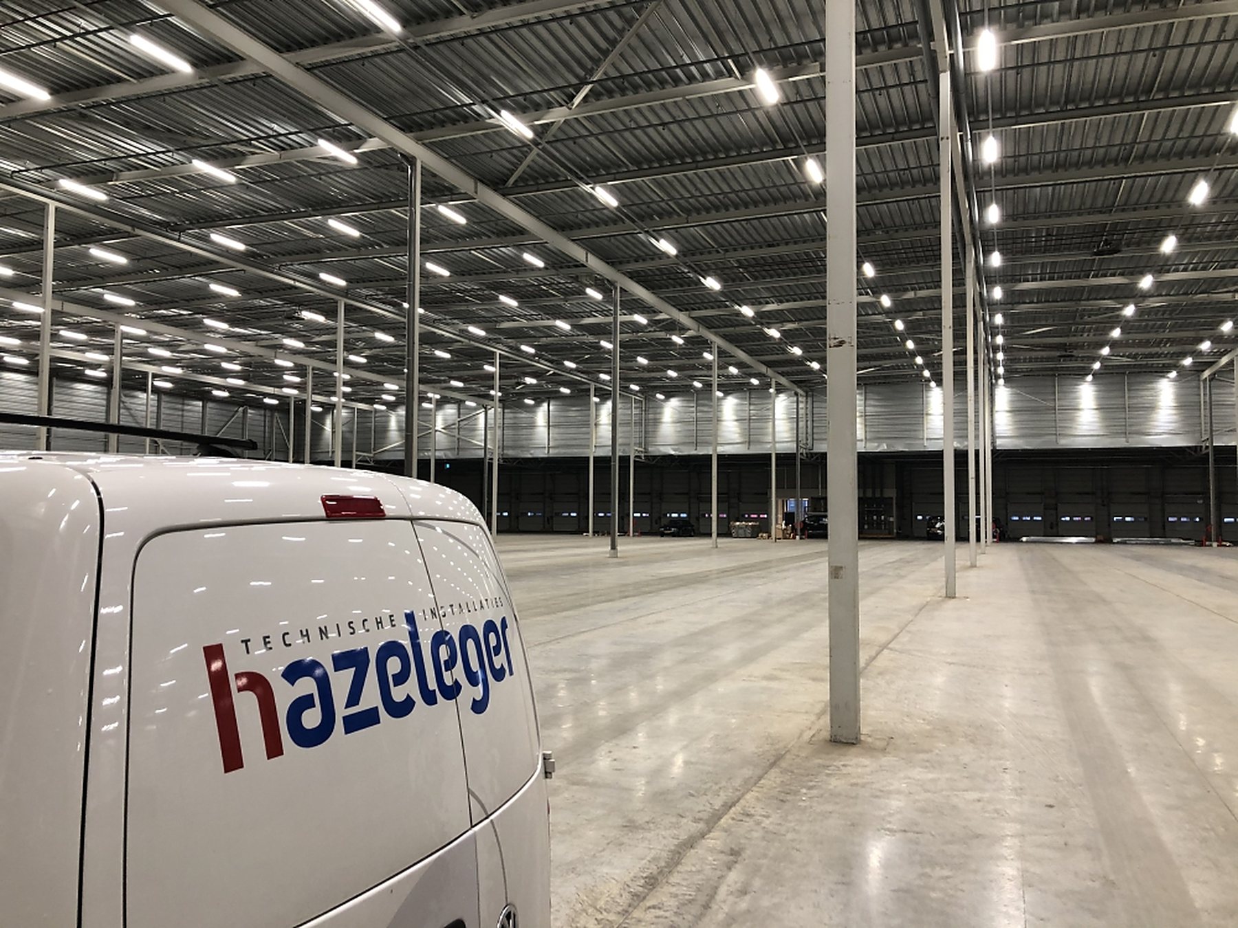 Bedrijfshal met een complete lichtinstallatie en een bedrijfsbus van Hazeleger