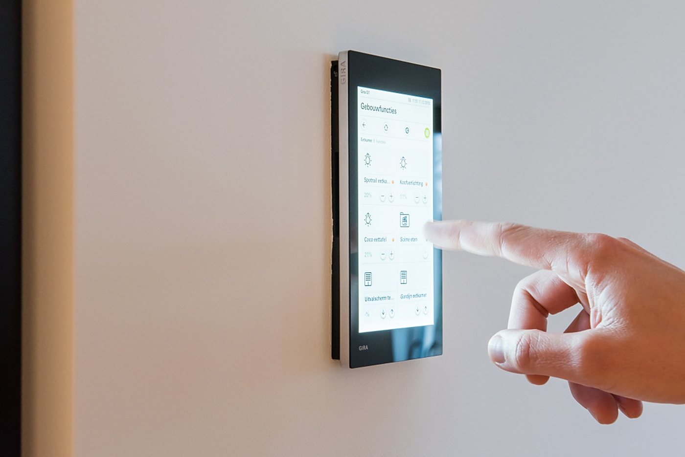 Hand bedient een KNX-wandpaneel in een woning