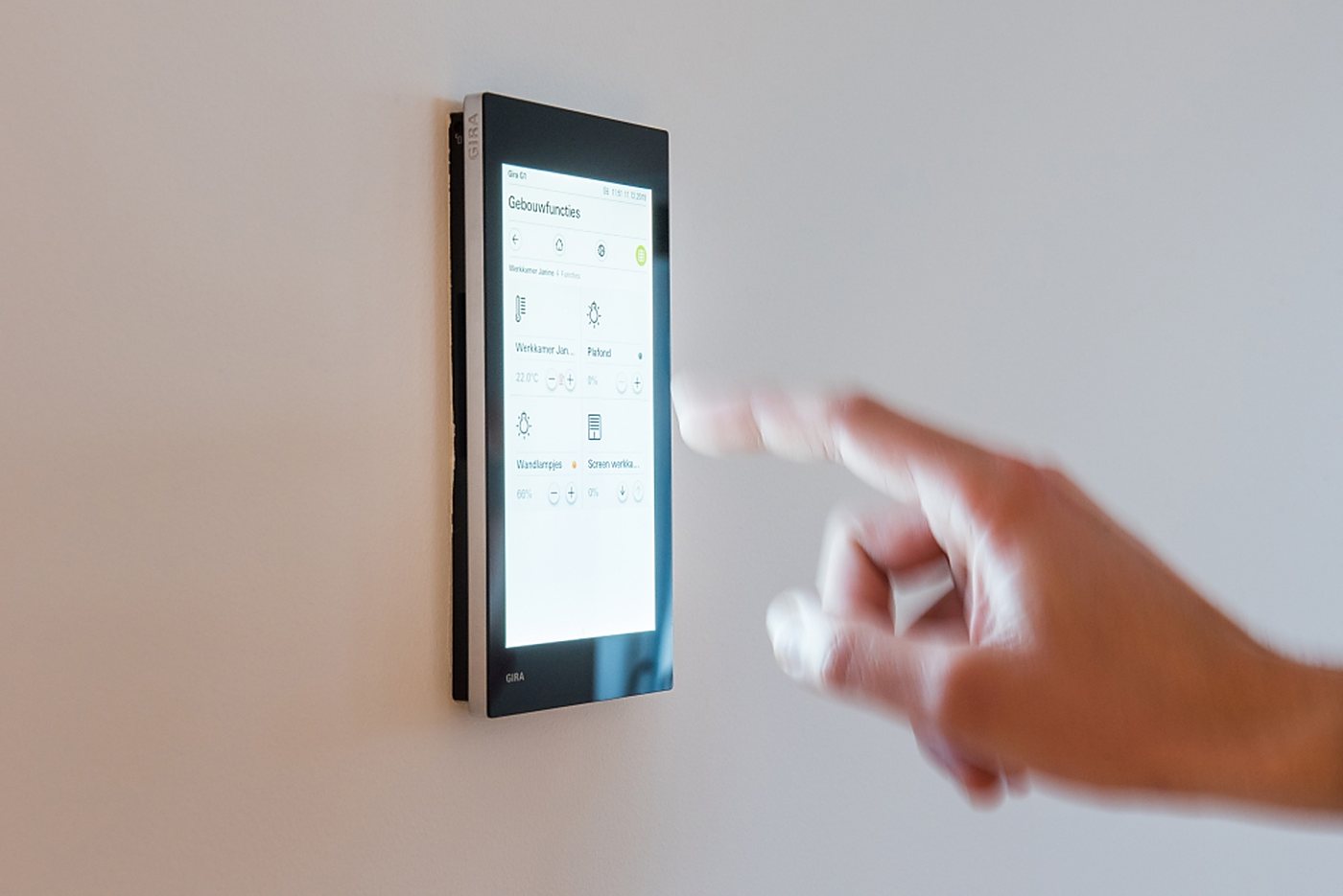 Hand bedient een KNX-wandpaneel in een woning