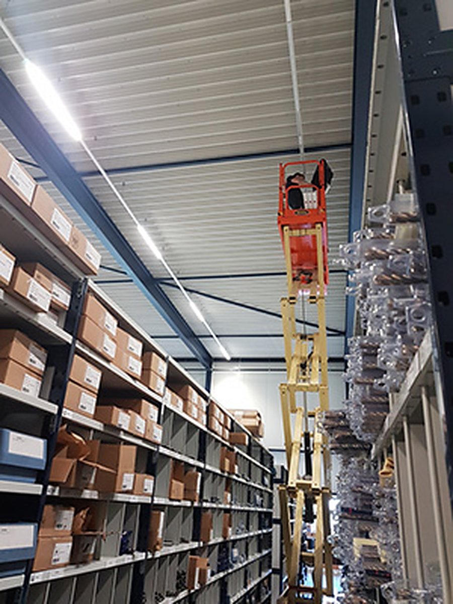 Magazijnstelling met energiezuinige verlichting en een hoogwerker