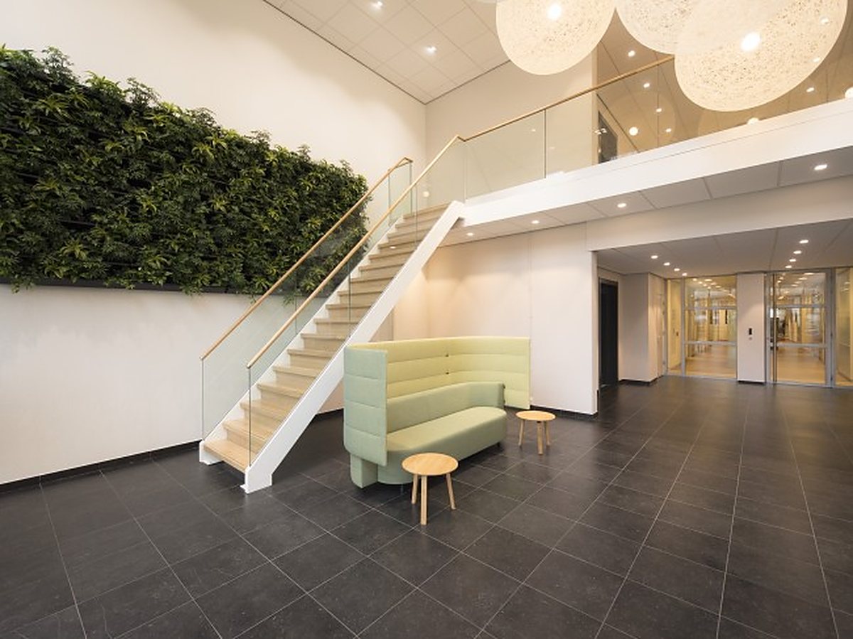 Entreehal met trap en groene wand bij Nysingh in Arnhem