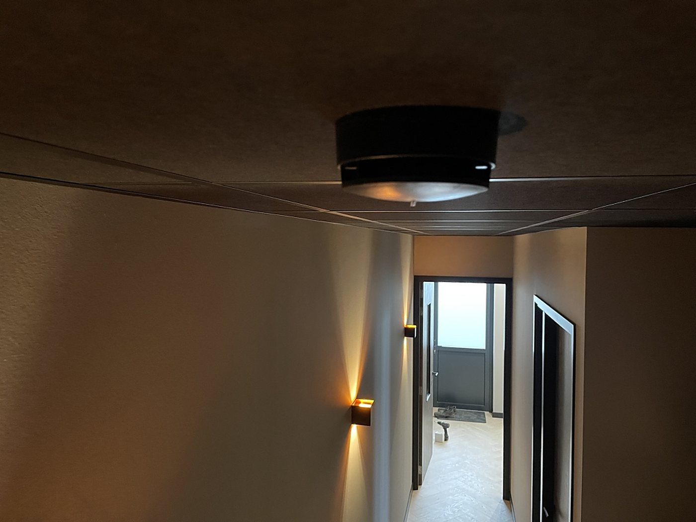 Rookmelder aan het plafond van een verlichte gang